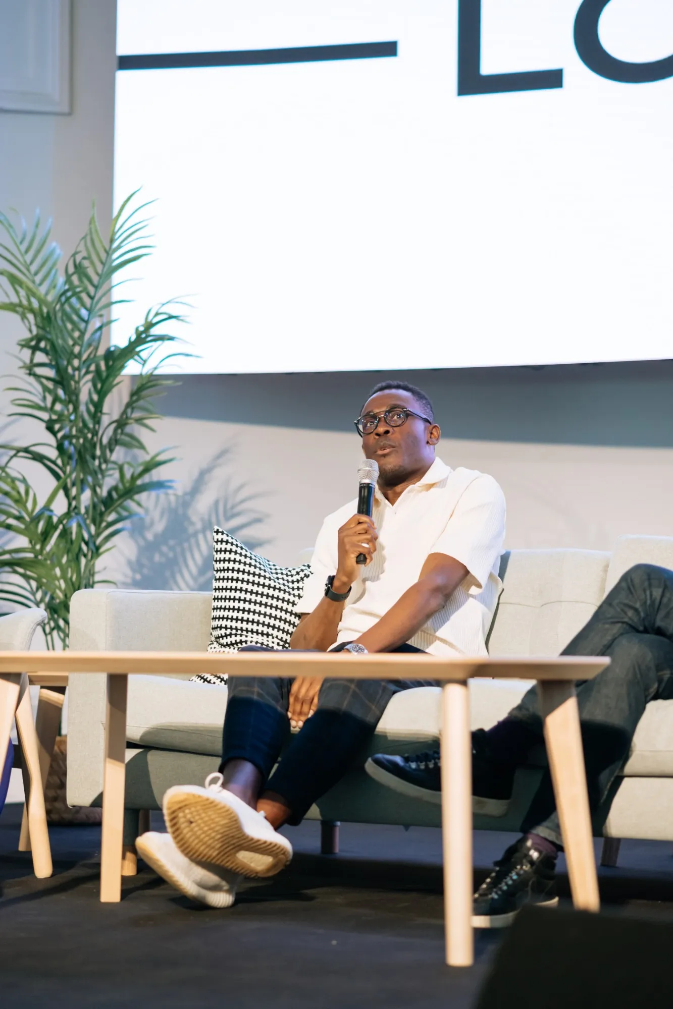 Peter answering a question with a microphone on a panel sofa at Barratt Homes
