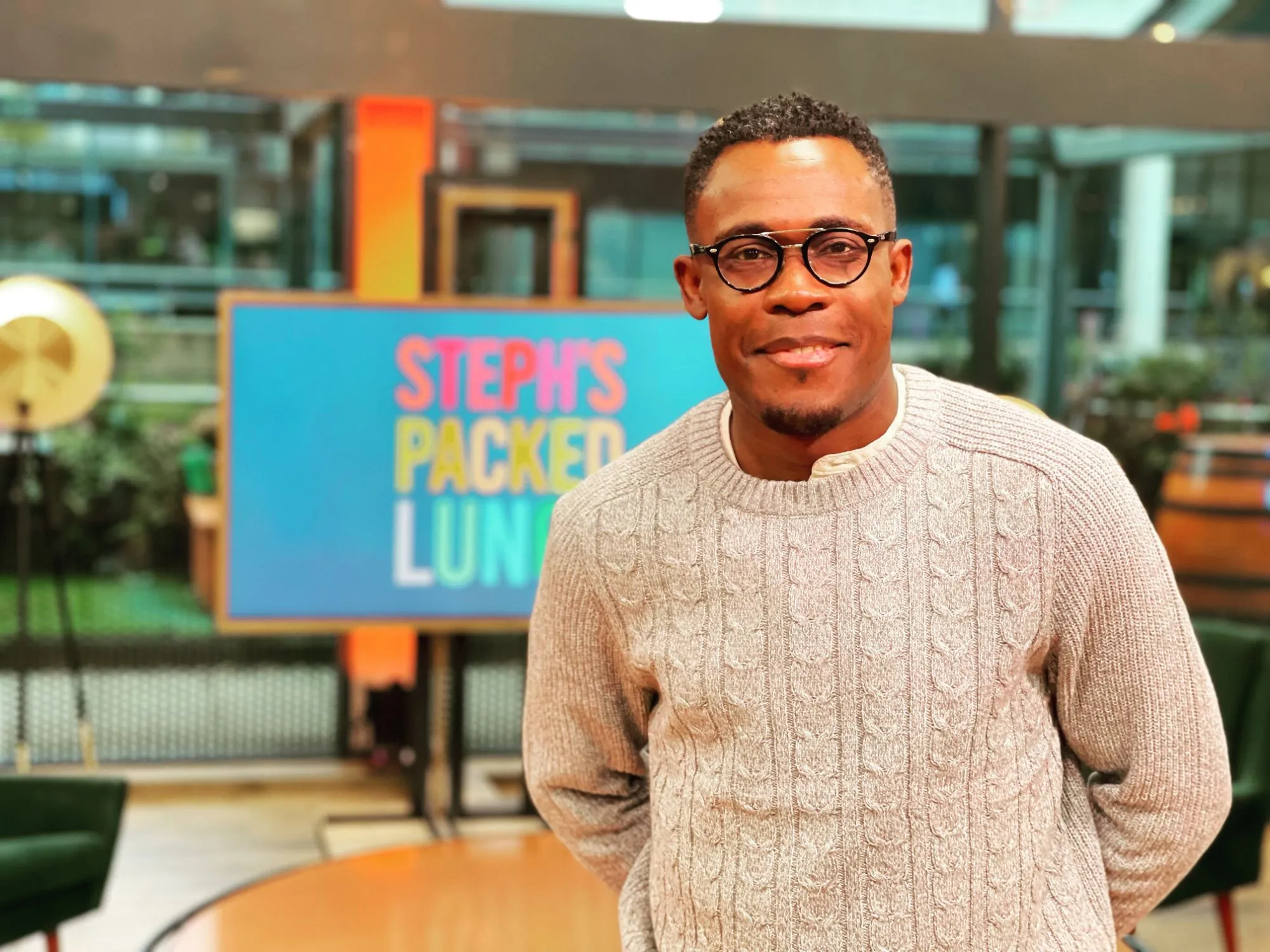 Peter smiling on the Steph’s Packed Lunch set, the show’s sign behind him